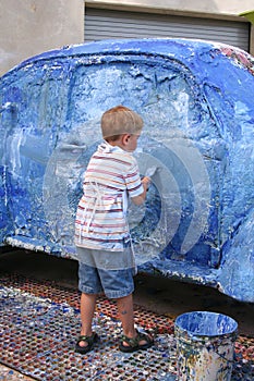 Boy artistically paints car