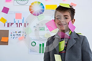 Boy as business executive with sticky notes on his body