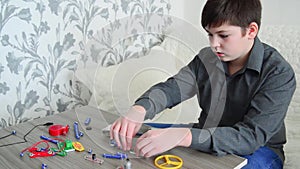 Boy assembles the electrical circuit from constructor