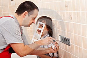 Boy assisting his father in electrician work