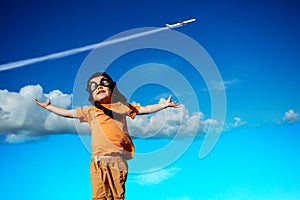 Boy in aviator hat and googles over blue sky