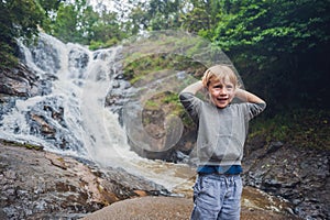 Boy in the background of beautiful cascading Datanla waterfall In the mountain town Dalat, Vietnam