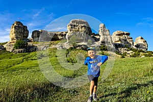A boy on the background of a picturesque view of the Bakhchisarai sphinxes. Bakhchisarai. May 2021