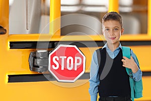 Boy with backpack near school bus. Transport for students