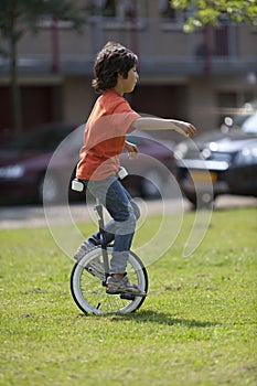 Boy balancing on a unicycle photo