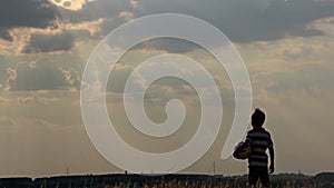 Boy with a ball in a field at sunset, boy dreams of becoming a soccer player