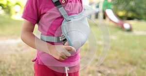 A boy with a bandage on his arm in an open space. Limited human movement. Children's injuries