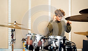 Boy banging on a drum kit. Lesson at the music school.