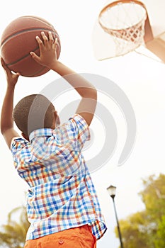 Boy On Basketball Court Shooting For Basket