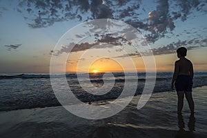 Boy bathing on the beach at dusk