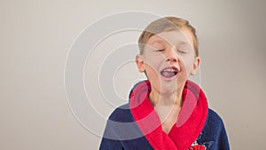 boy in a bathrobe posing at the camera on a white background