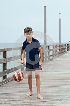 Boy on the beach with ball. Family vacation by the sea. Active lifestyle