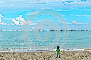 Boy on beach looking at sea