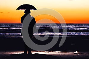 Umbrella strobist - boy stationary on beach photo