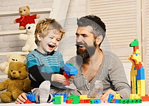 Boy and man play together. Dad and kid with toys
