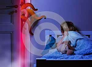 Boy in bedroom hide under blanket from nightdream monster