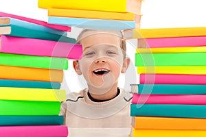 Boy behind pile of books
