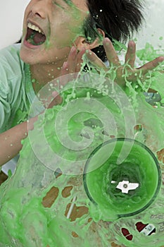 Boy being splashed by overflowing blender photo