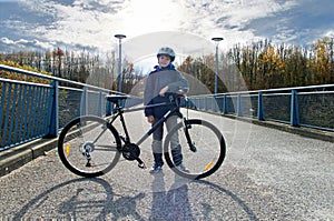 Boy with bicycle on the road