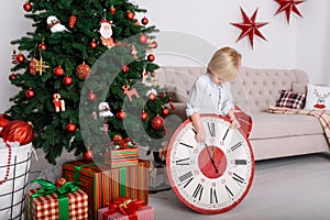 Boy with a big clock in Christmas tree