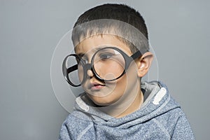 Boy with big glasses very serious and thinking