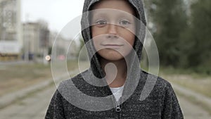 Boy in a black hood outside