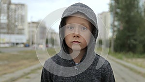 A boy in a black hood on the street