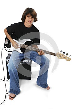 Boy With Black And White Bass Guitar Sitting On Amp