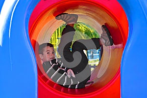 Boy in black and white sweatshirt plays in the playground in