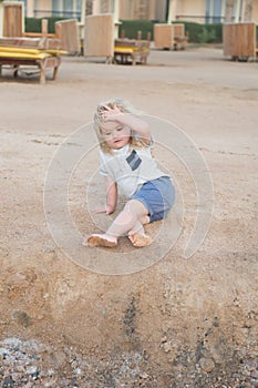 Boy with blond hair have fun on sand