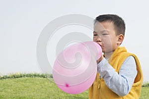 Boy blowing balloon
