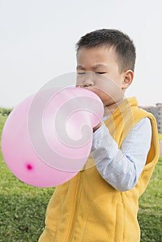Boy blowing balloon