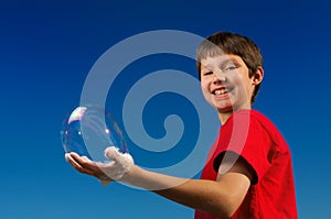 Boy blowing a bubbles and holding it in his hand !