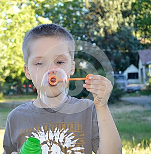 Boy blowing bubbles in the summer photo