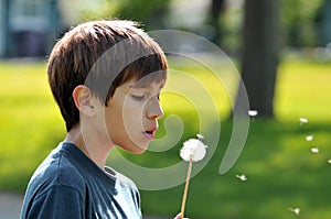 Boy blowing a dandelion