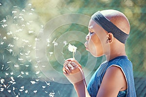 Boy, blowing a dandelion and making a wish with a black child outside on a basketball court while holding a magical