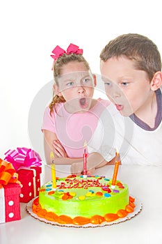 Boy blowing out girl's candles