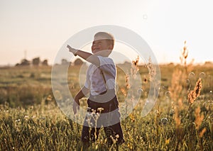 Boy blowing soap bubbles while an excited kid enjoys the bubbles. Happy kid in a meadow