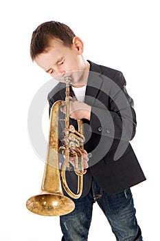 Boy blowing into a trumpet against white background