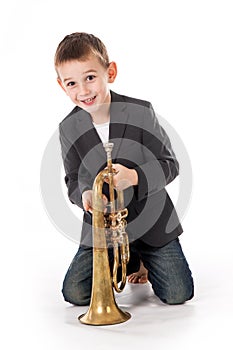 Boy blowing into a trumpet against white background