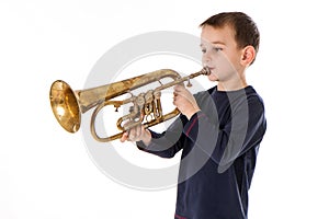 Boy blowing into a trumpet against white background