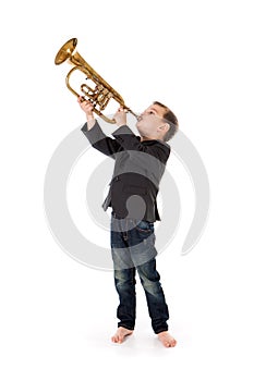 Boy blowing into a trumpet against white background