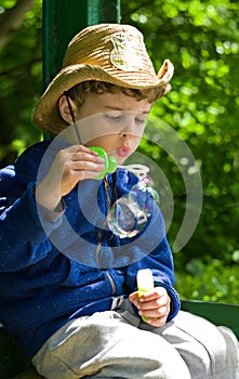 Boy blows soap bubbles