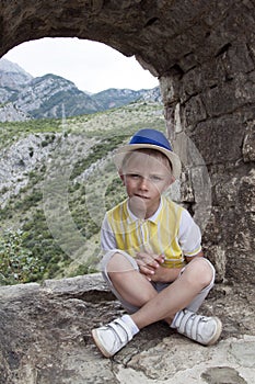 boy in a blue hat sitting in the observation window of the ancie