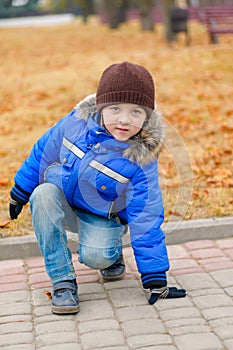 Boy in blue jacket, crouched down