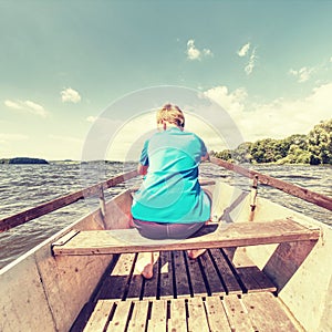 Boy in blue with life jackets at legs floats on vessel boat