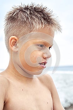 Boy with blue lips frozen from swimming in cold sea water