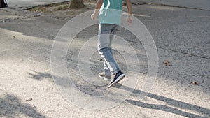 Boy in blue shirt, jeans and glasses playing hopscotch