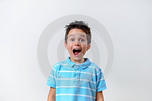 A boy in a blue T-shirt looks at the camera and screams