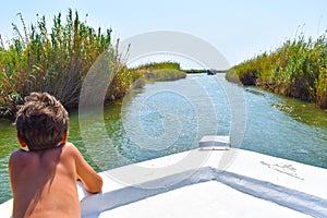 Boy on the boat, advancing in the river